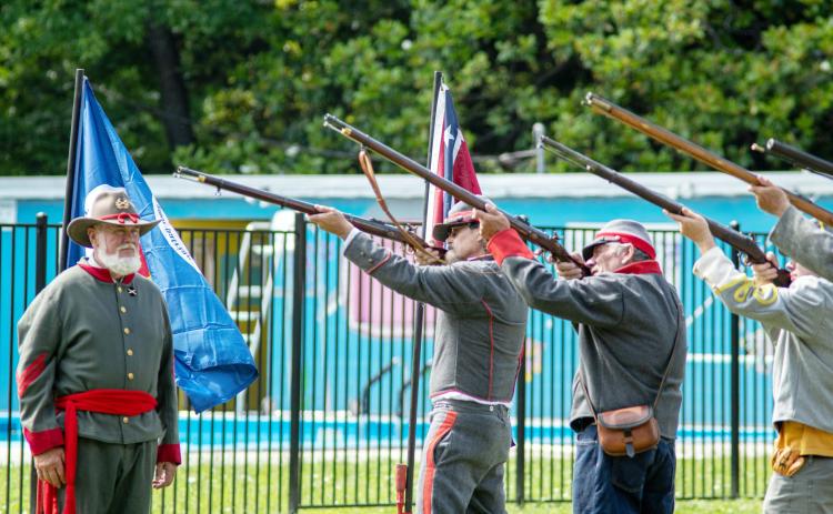 LEFT- Commanded by Barry Kniffen, left, the local chapter of Sons of Confederate Veterans (SCV) performed military honors via firing party utilizing period muskets on Monday at the annual Memorial Day Observance at American Legion Park. Pictured firing, left to right is Wayne Carlile, Danny Masters, Bayden Fleming. Sandy Kothmann, photo.