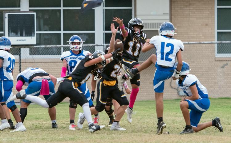 LOTS OF ACTION going on during Menard's 63-12 win over Nueces Canyon last Friday. Pictured blocking a Panther extra point is Hunter Squiers (#0), Benjamin Burch (#26), Maddox Saiz (#11), and Korbin Squiers in the back (#15). Nora Davis, photo.