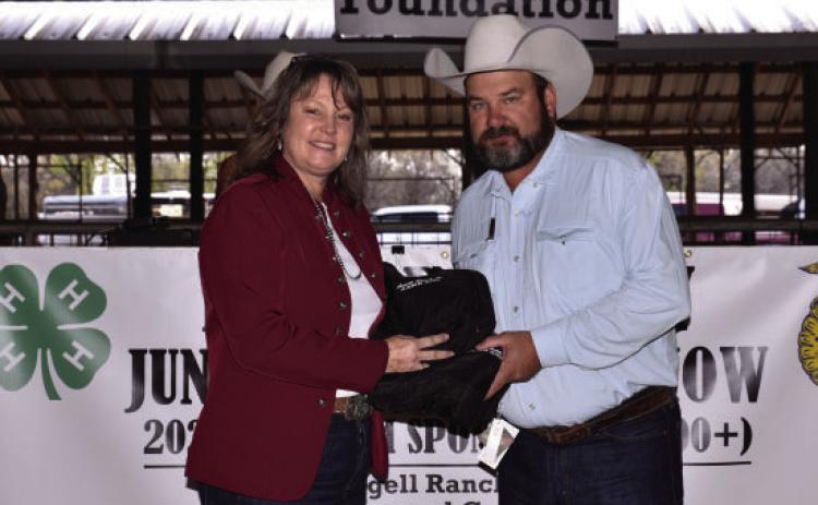 Payton Chambless accepts a thank you gift on behalf of O Diamond Ranches from Texas Agrilife Exertion Agent Lisa Brown for being one of the top 2023 buyers.