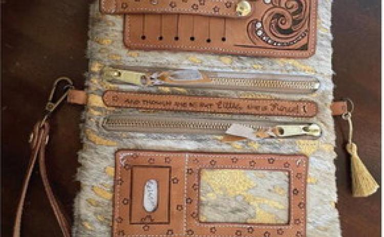 An inside view of the clutch Mews handcrafted for the contest. Complete with 6 card slots, a place for an ID, two zippered pouches and more. The middle leather strip is tooled with her favorite saying, “And although she be Little, she is Fierce.”