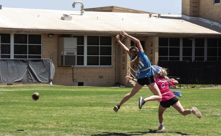 Senior receiver Addy Bannowsky makes a move to catch the pass, while avoiding defender Korah Mayfield. The play resulted in this dramatic photo by Sandy Kothmann. Fortunately for the football, it escaped the players, virtually untouched! (See left side of photo)